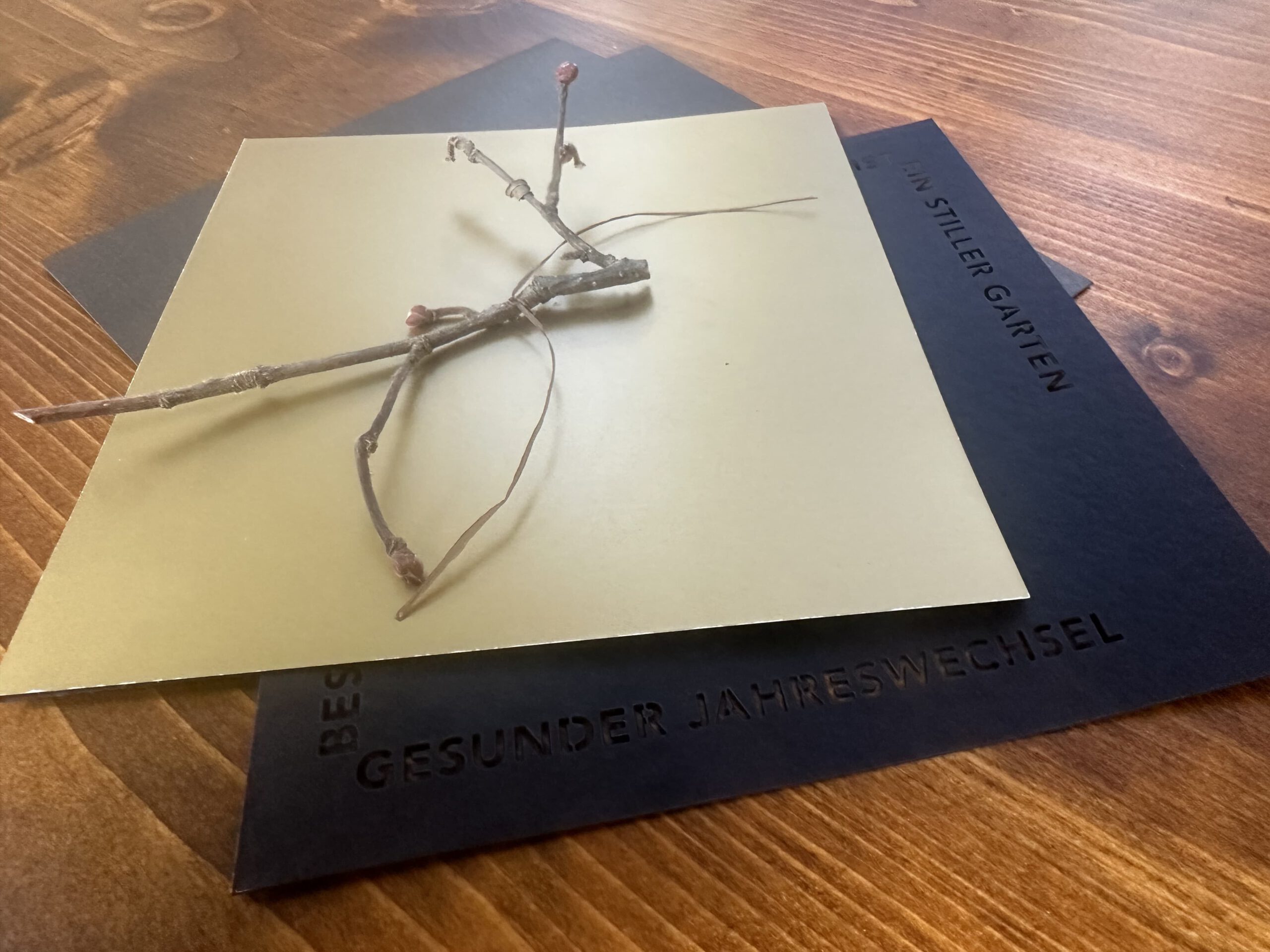 Individuelle Weihnachtskarten mit Goldpapier, gelasertem Text und echtem Ast als Verbindung