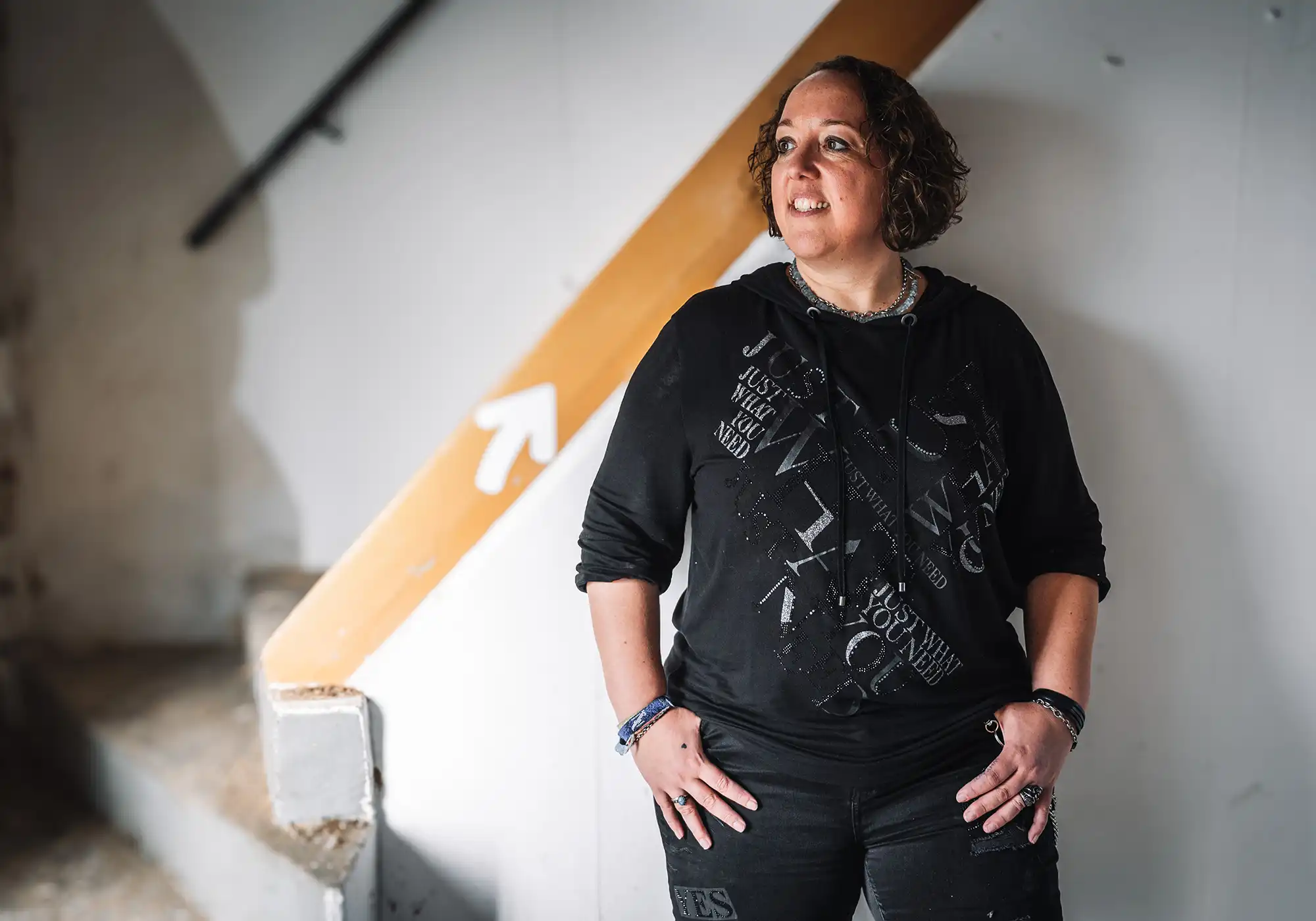 minschtl® steht in einem kreativen Raum und blickt nach oben. Die Szene zeigt einen Moment aus ihrem Ideenreich und macht ihre Haltung als Designer sichtbar. Das Bild unterstützt den Artikel über die Grundlagen gestaltende Beratung und zeigt den Weg hinter ihrer Arbeit.